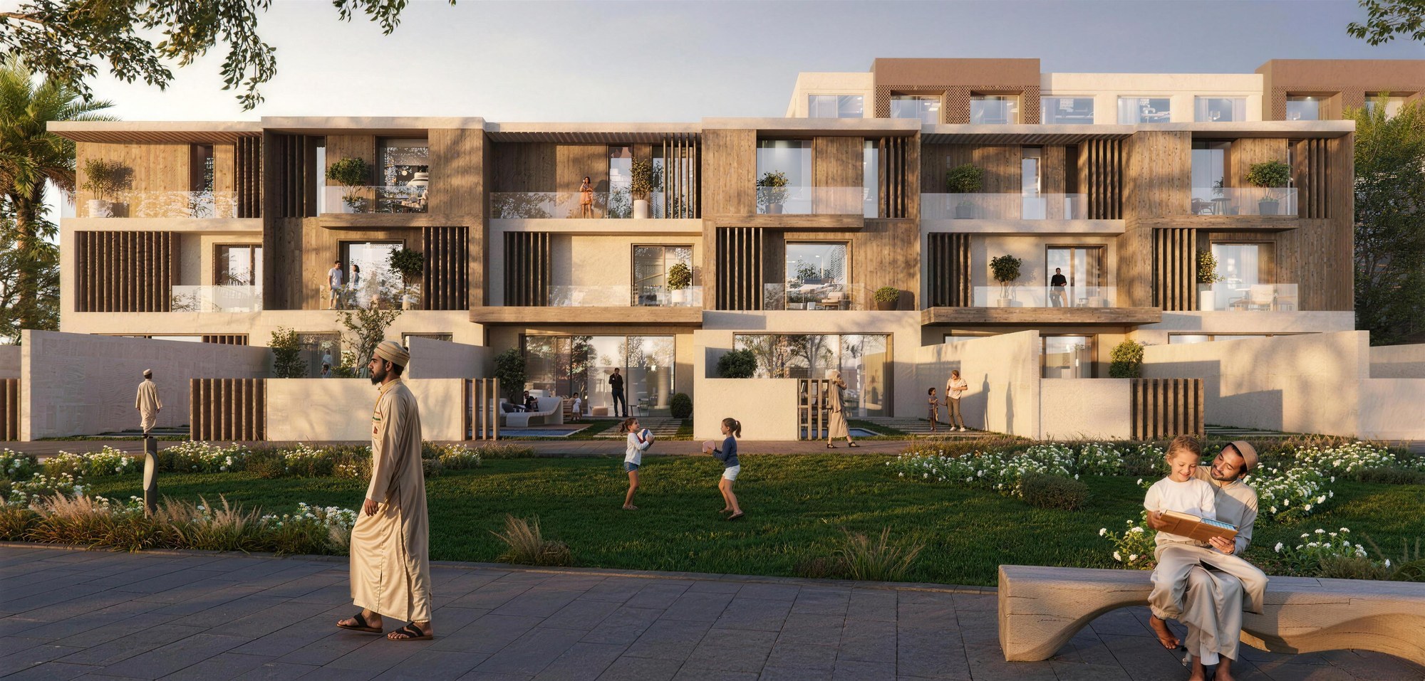 A family outside townhouses in Wadi Zaha, Sultan Haitham City