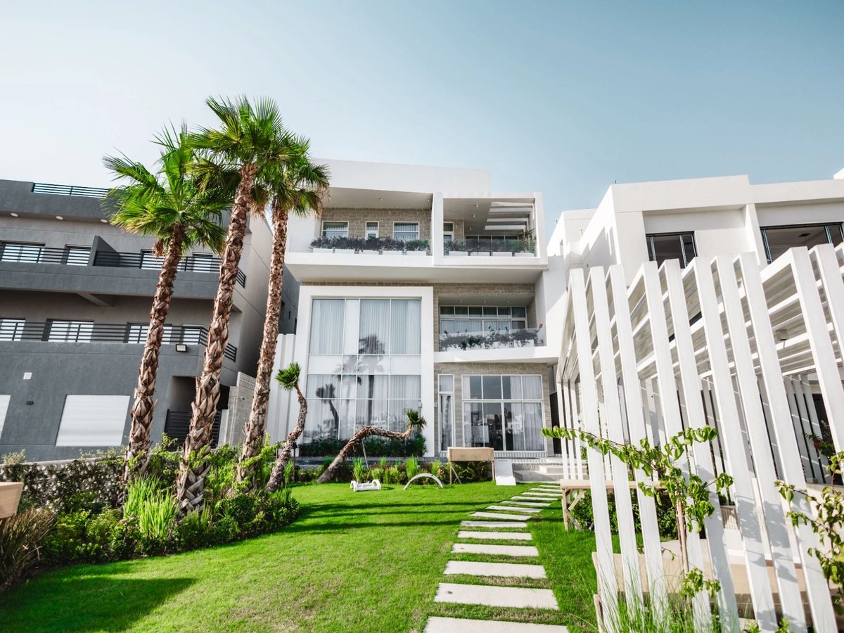 Modern white villa with garden and palms in Sabah Al Ahmad Sea City