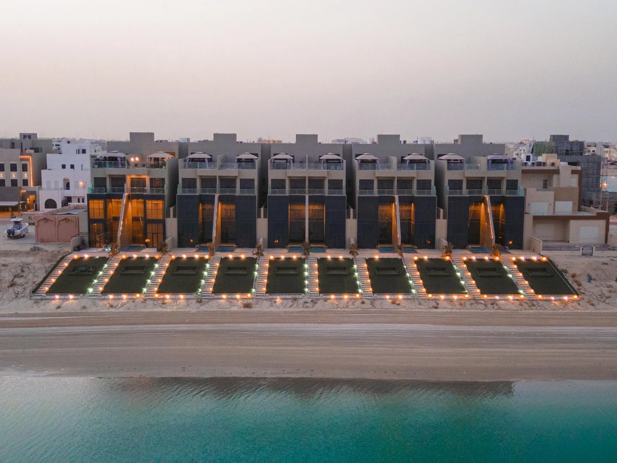 Row of beachfront villas at dusk on the Al Khiran coast
