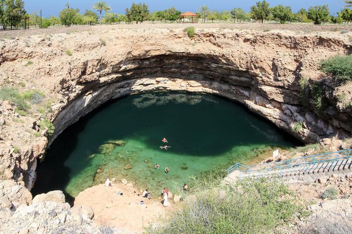 Turquoise water of the Bimmah sinkhole seen from the rim, with the stairway