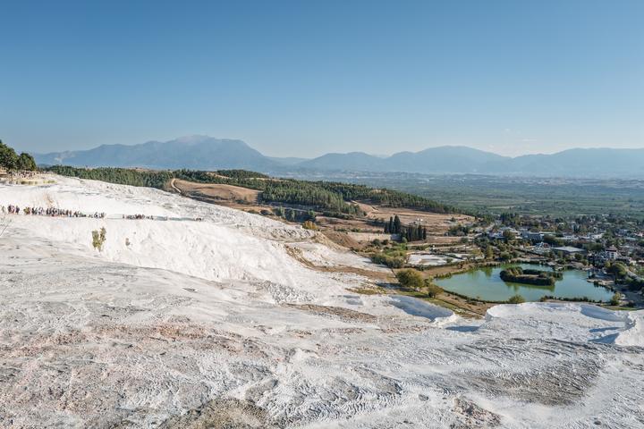 White travertine terraces of Pamukkale above the green plain of Denizli