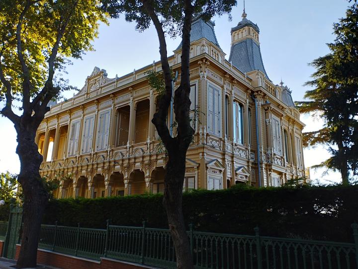 An ornate wooden mansion with turrets behind a green fence on Büyükada, Princes' Islands