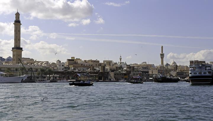 Wooden abras crossing Dubai Creek below the minarets of Deira