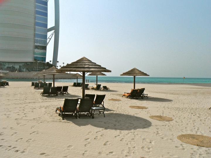 Sand and beach umbrellas below the Burj Al Arab